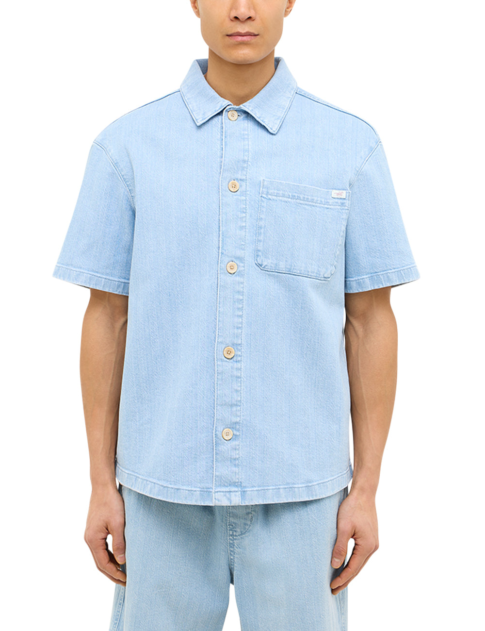 Cămașă Boxy Phoenix Denim albastru deschis, față, purtată cu pantaloni denim asortați