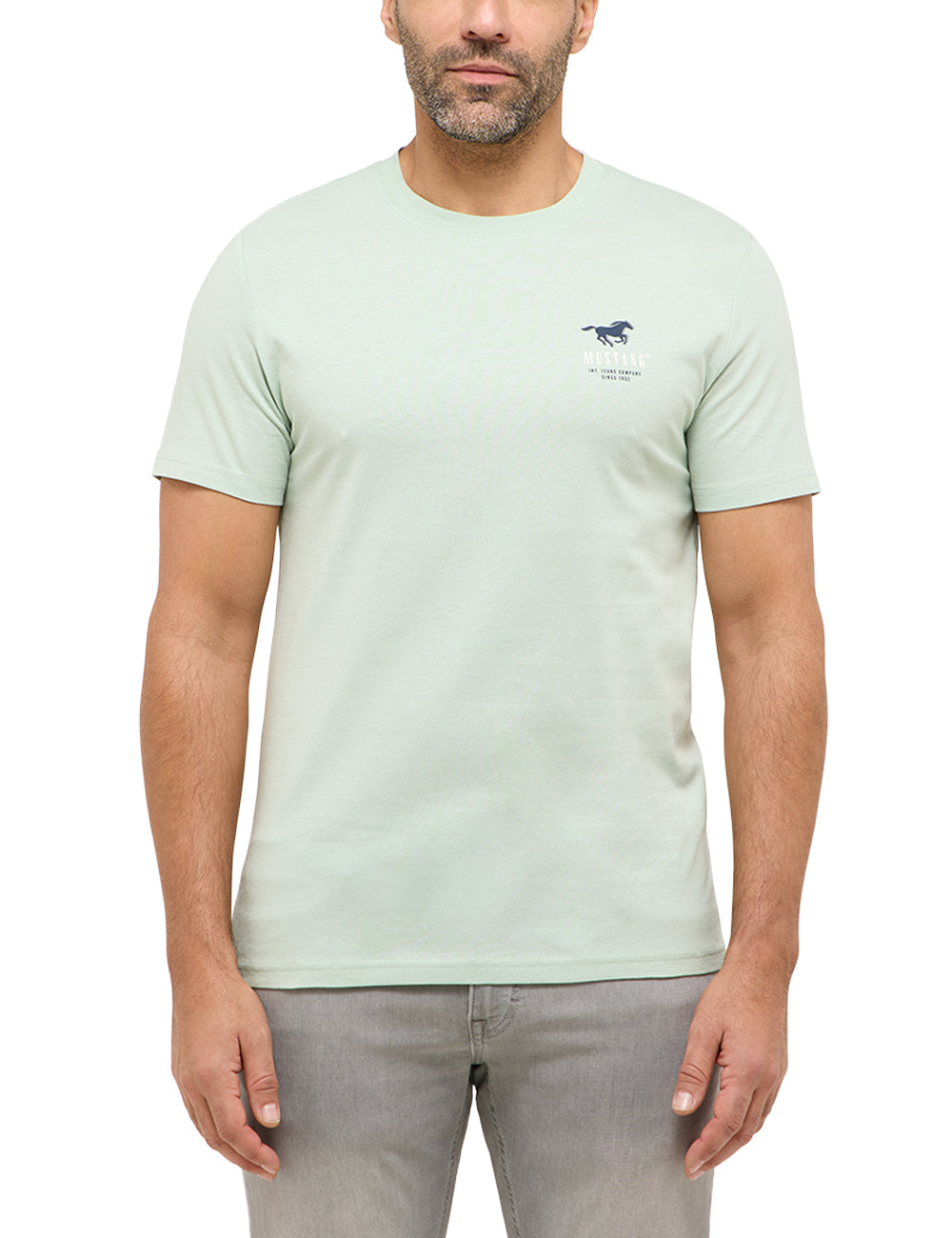 Tricou Austin verde deschis, față, purtat pe model, siglă mică pe piept cu cal alergând și textul „Mustang”
