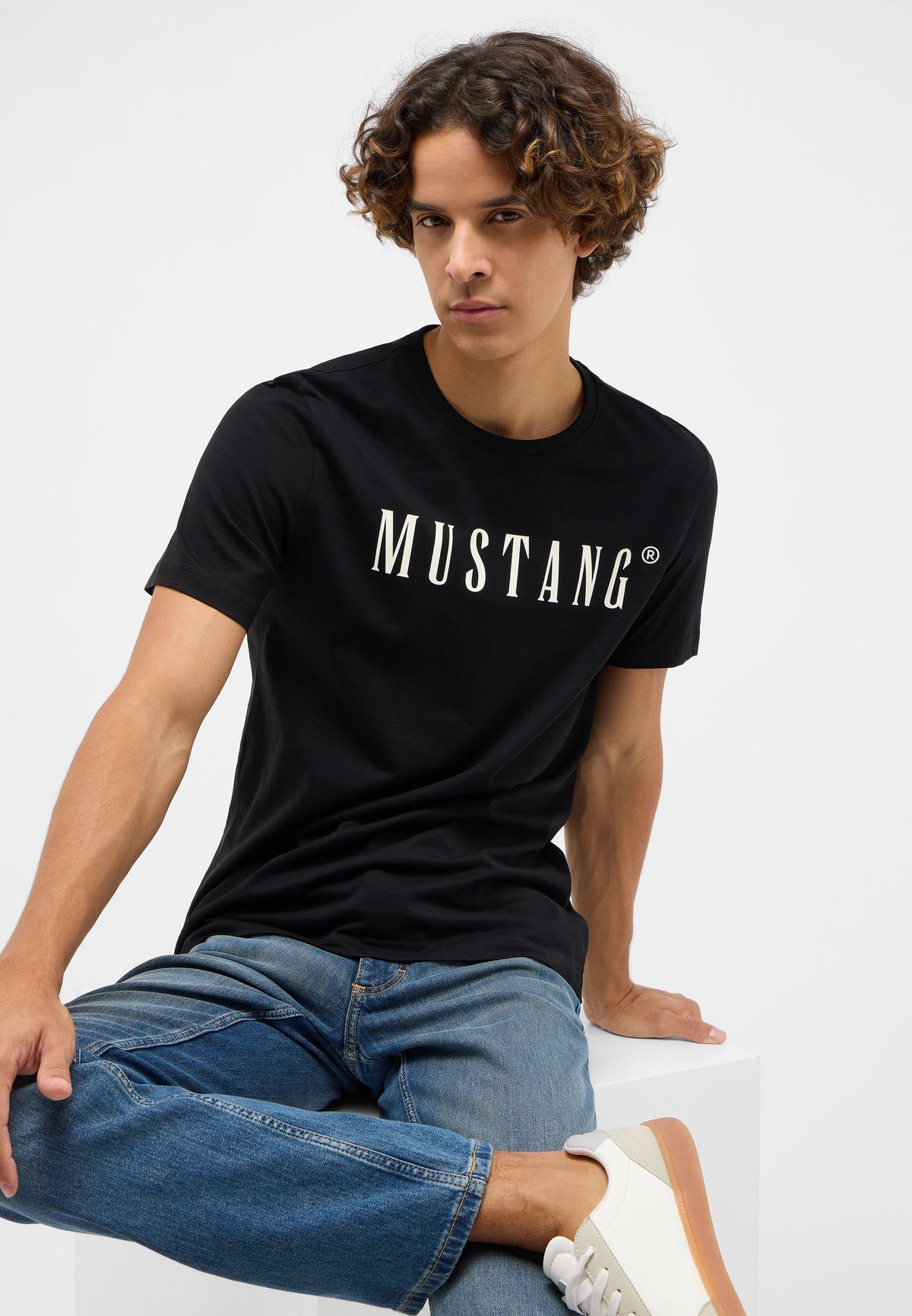 Tricou Austin negru, față, imprimeu alb-crem „MUSTANG” pe piept, model așezat, purtat cu blugi
